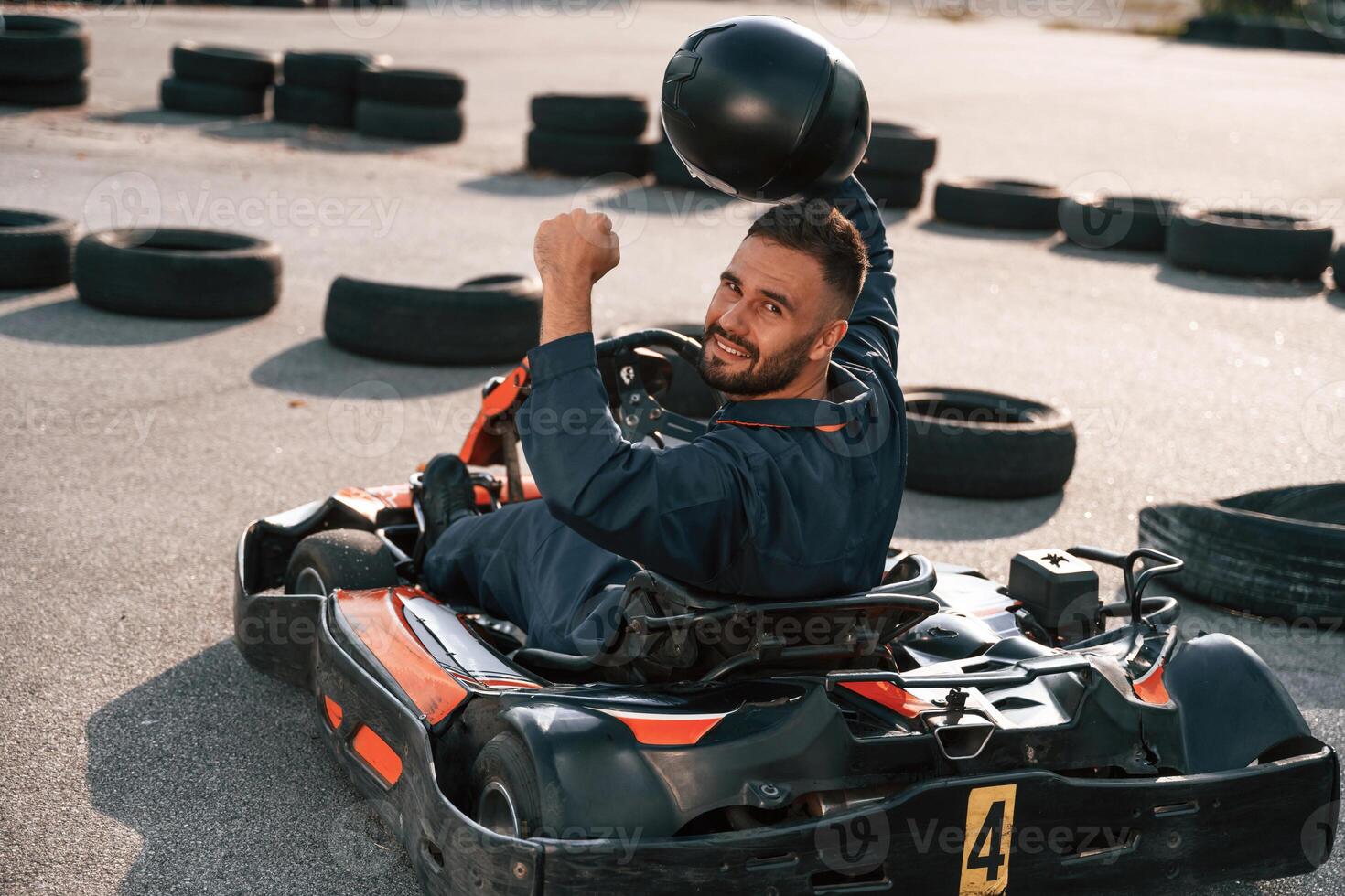 Hands, are up, celebrating victory. Man i,,s outdoors, kart racing conception photo