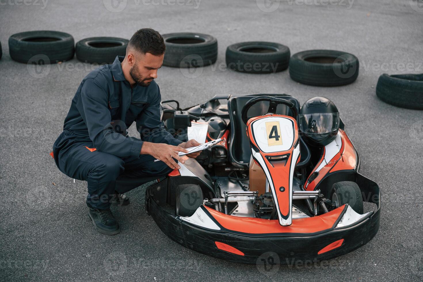 With notepad ,in hands. Man is outdoors, kart racing conception photo