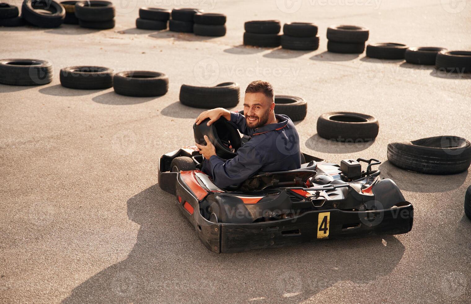 Looks,, behind while riding. Man is outdoors, kart racing conception photo