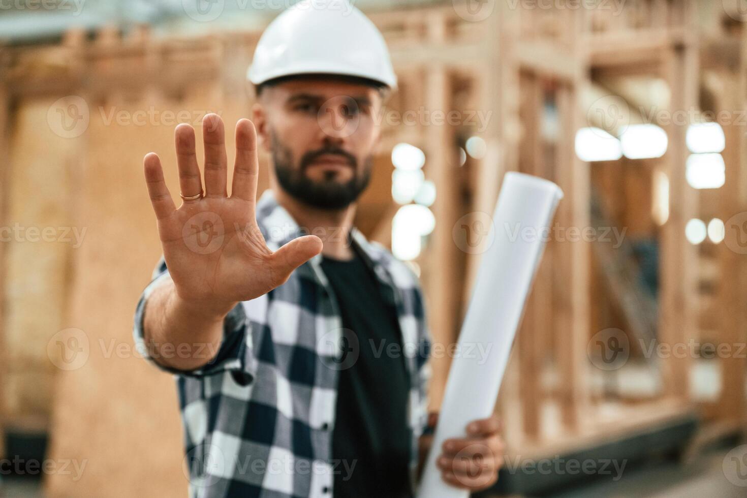 Stop hand gesture,, no trespassing,. Industrial worker in wooden warehouse photo