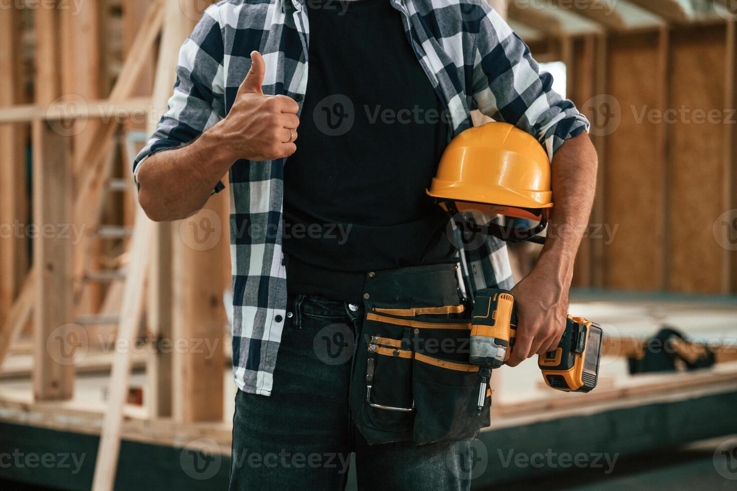 Job ,is going fine, showing, thumb up. Industrial worker in wooden warehouse photo