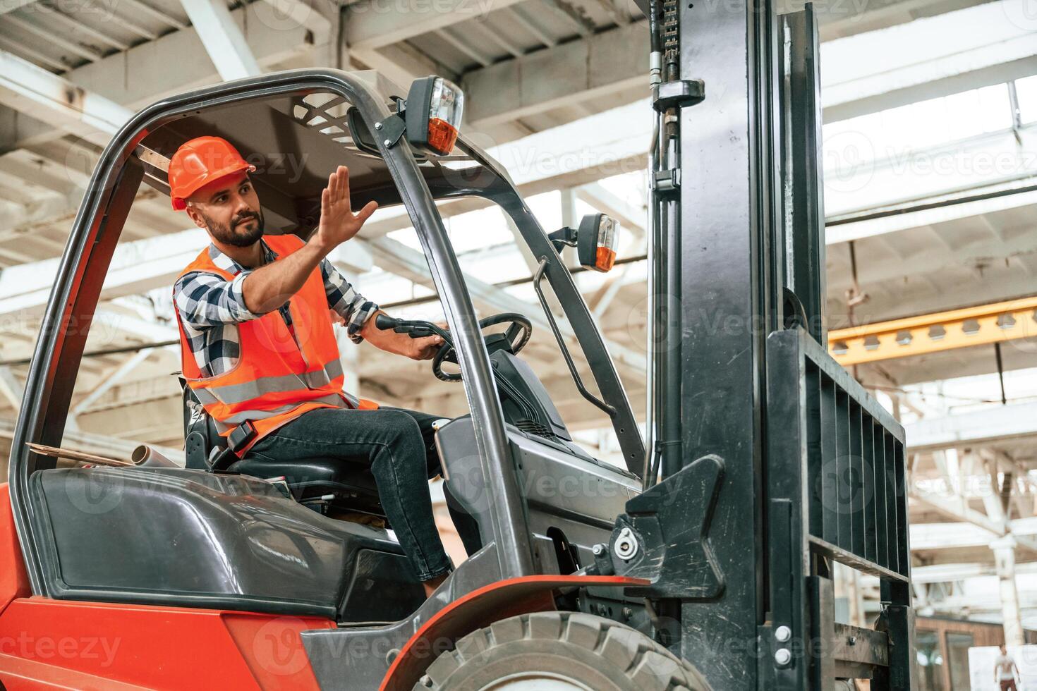 Driving the ,forklift. Industrial worker in wooden warehouse photo