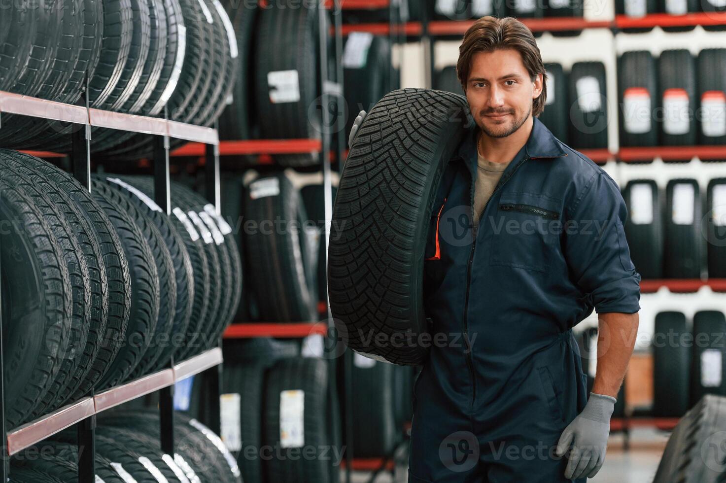 Moving the tire.... Man is in the tire fitting car service photo