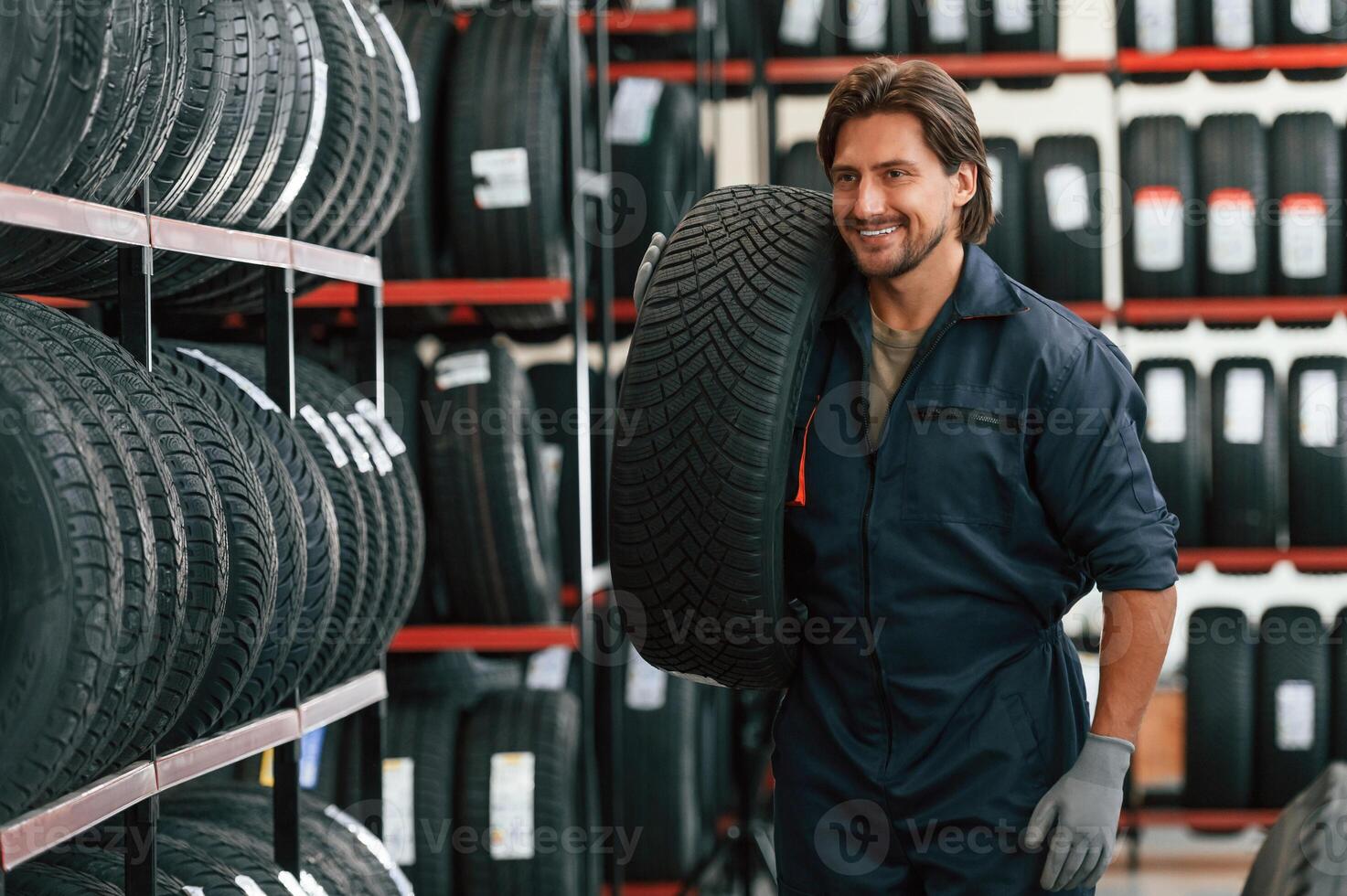 Moving the tire. Man is in the tire fitting car ,,,service photo