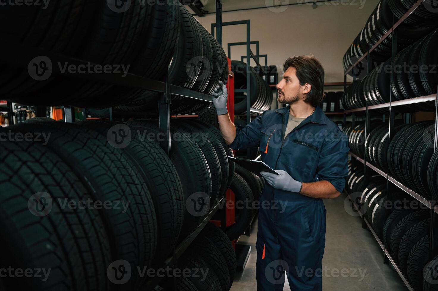 Work in progress, manager is in warehouse. Man is in the tire fitting car service photo