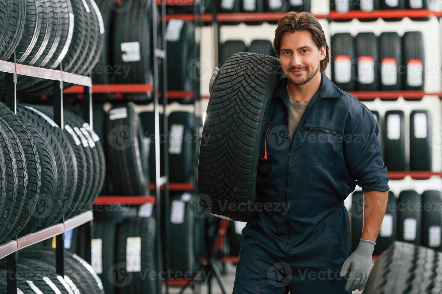 Moving the tire. Man ,,is in, the ,tire fitting car service photo
