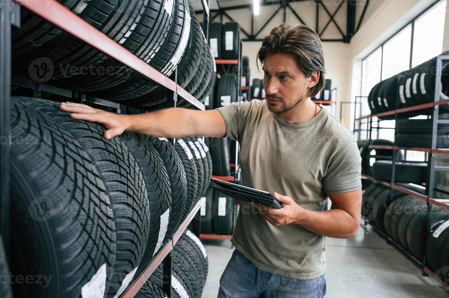 Quality ,control, manager is looking ,,for stuff. Man is in the tire fitting car service photo