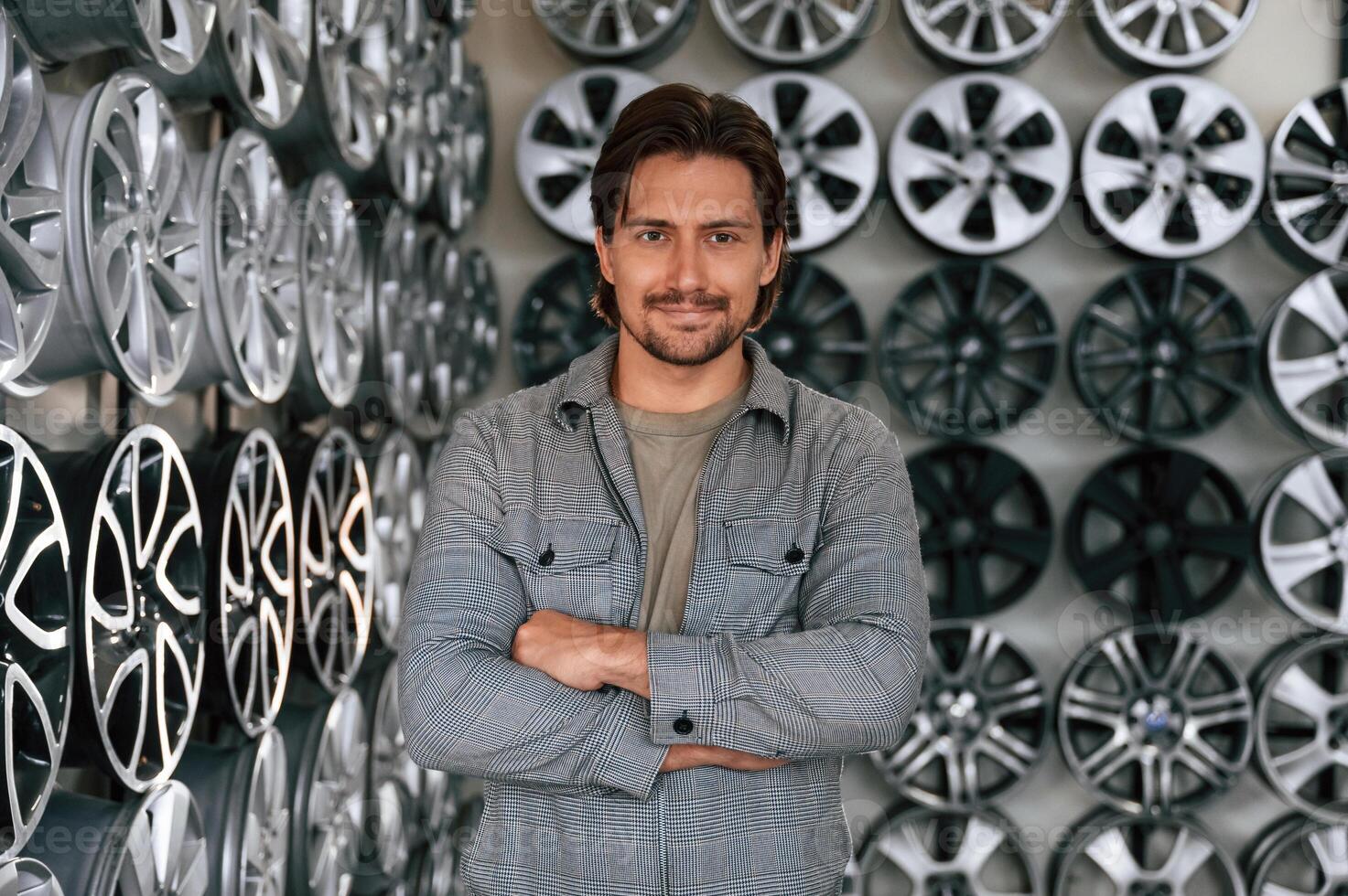 Many ,of the disks on ,,walls. Man is in the tire fitting car service photo