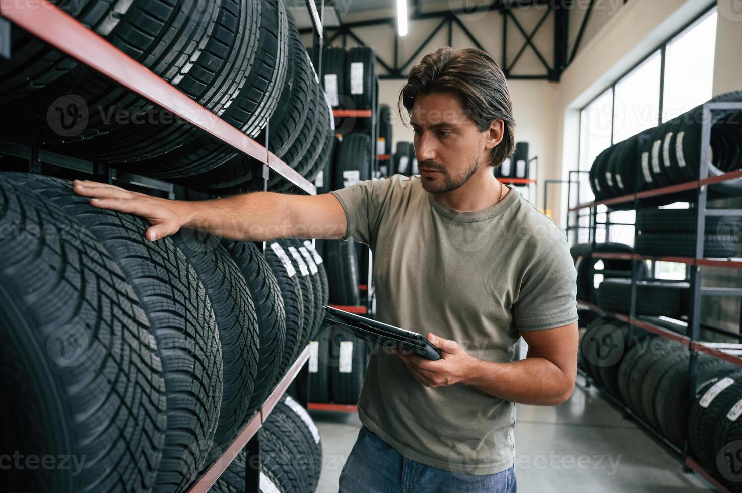 Quality, control, manager is looking for ,,stuff. Man is in the tire fitting car service photo