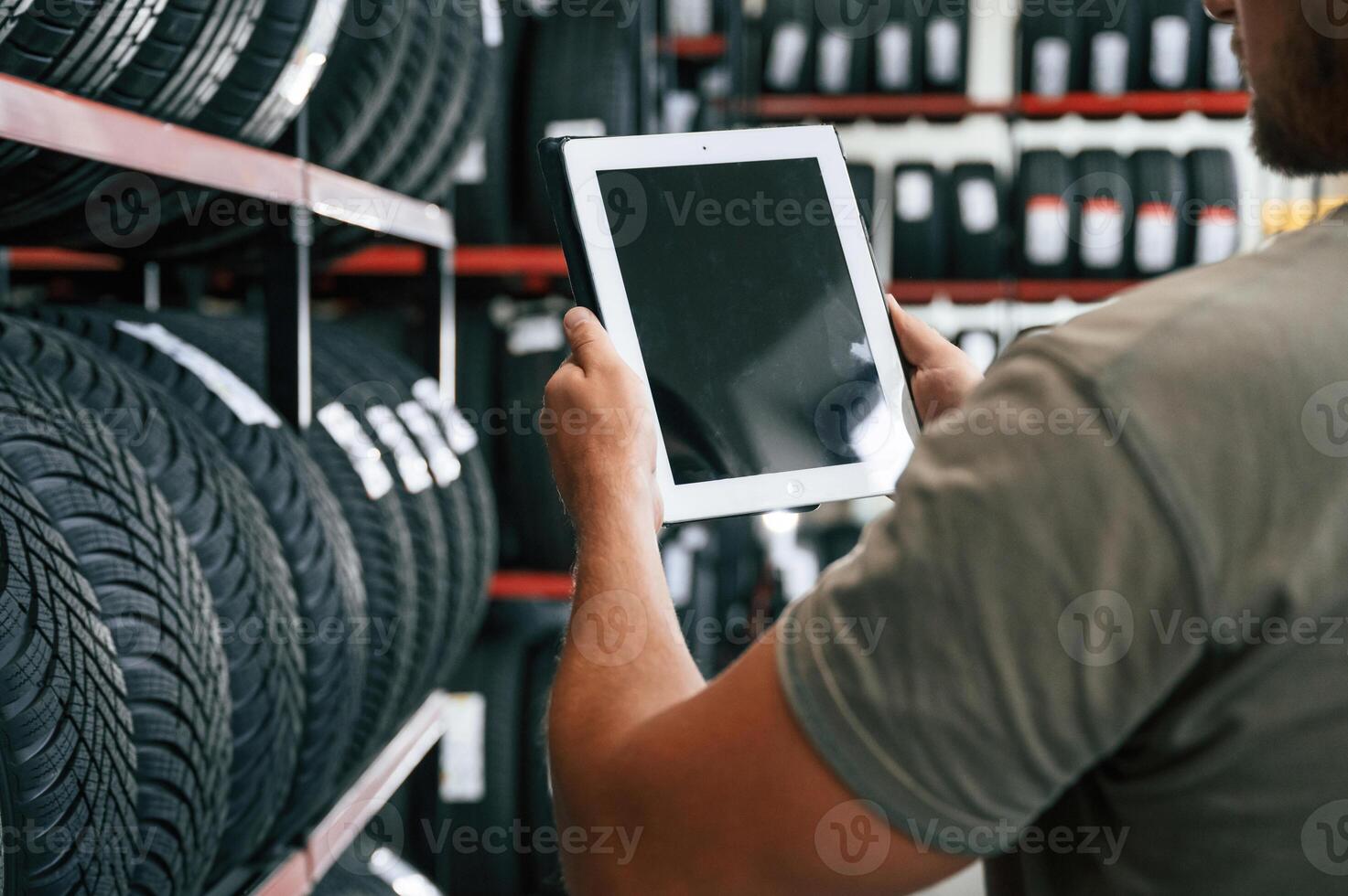 Copy space ,,on ,the digital tablet. Man is in the tire fitting car service photo