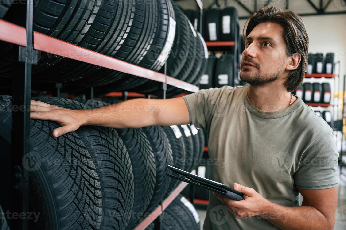 Quality ,control,, manager is looking for stuff. Man is in the tire fitting car service photo
