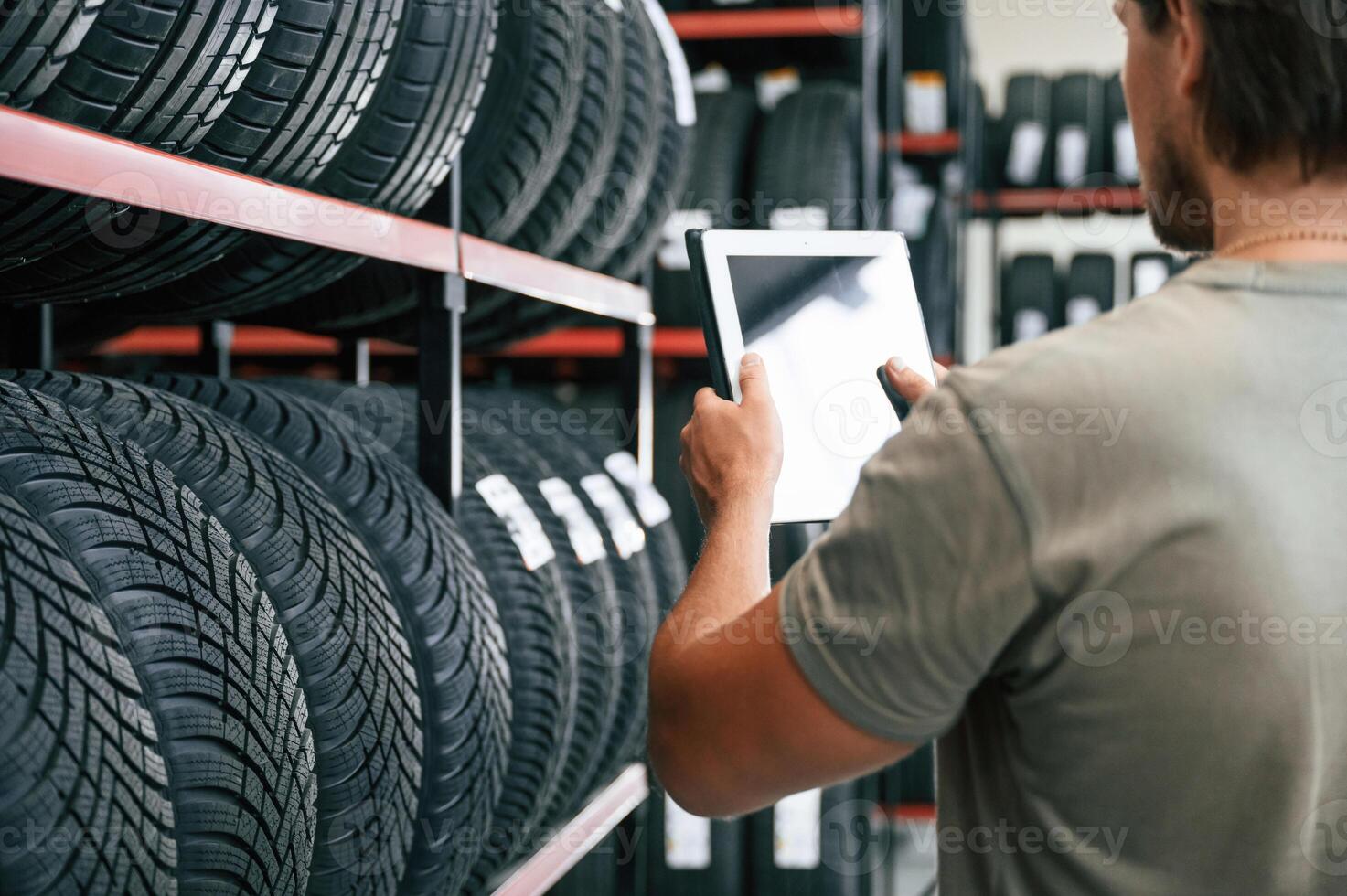 Copy space, on the digital tablet. Man is in the tire fitting car service photo