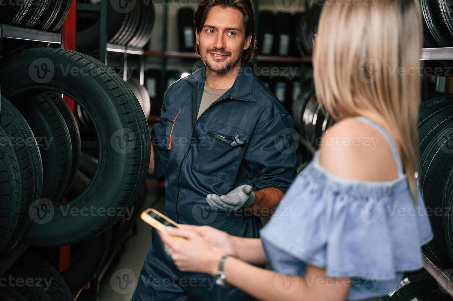 Woman ,is, in, the tire fitting auto shop with worker photo