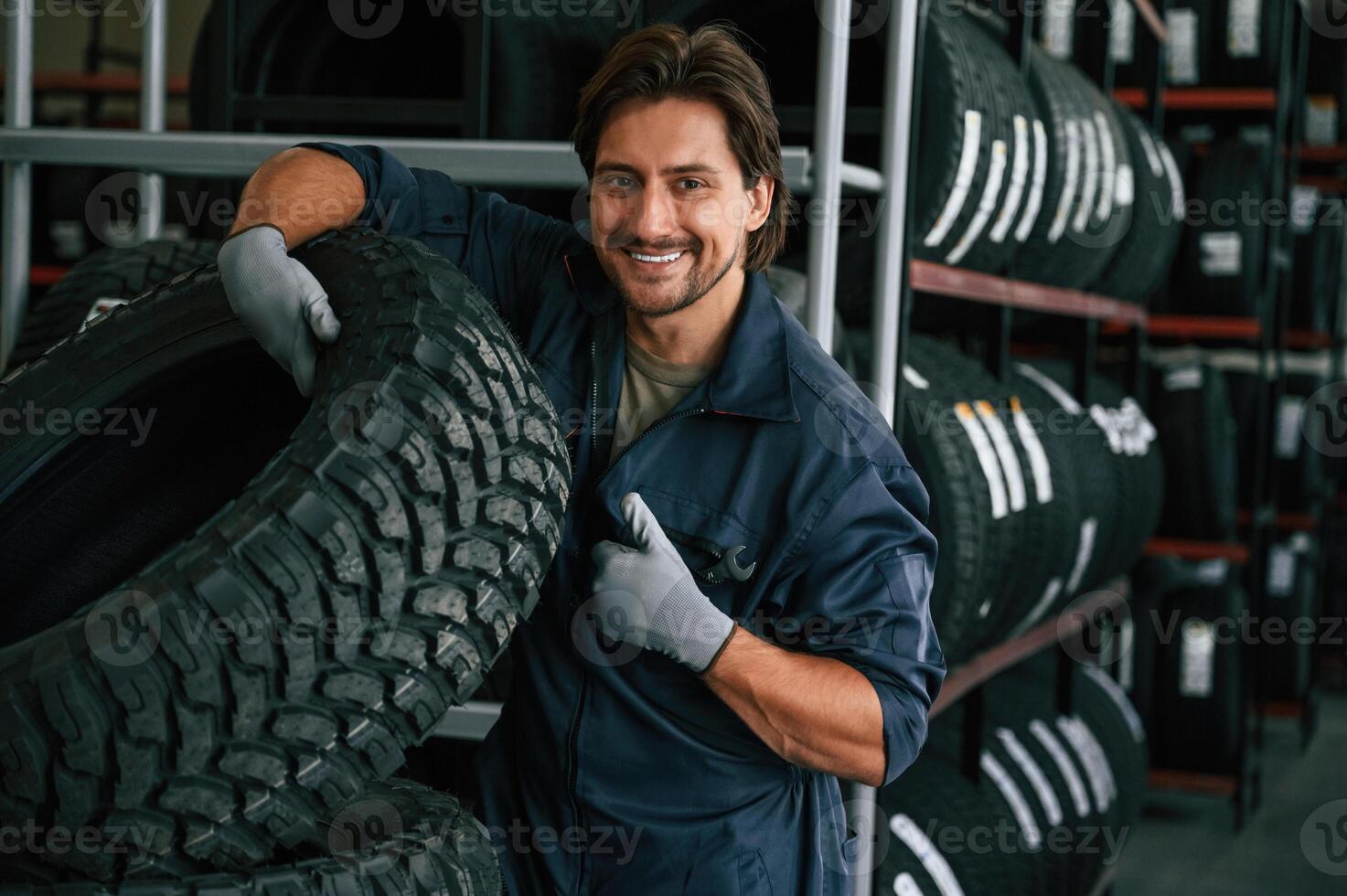 Professional, worker is,, with wheel. Man is in the tire fitting car service photo