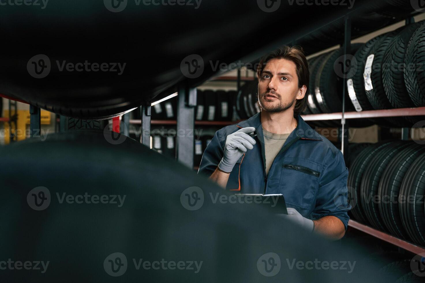 Collecting information, counting, notepad.. Man is in the tire fitting car service photo
