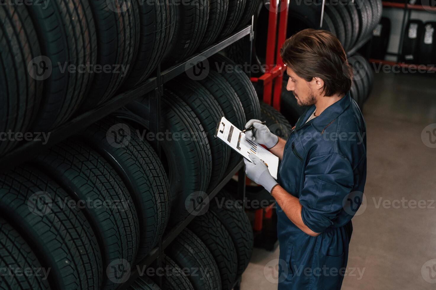 Collecting ,information, ,counting, notepad. Man is in the tire fitting car service photo