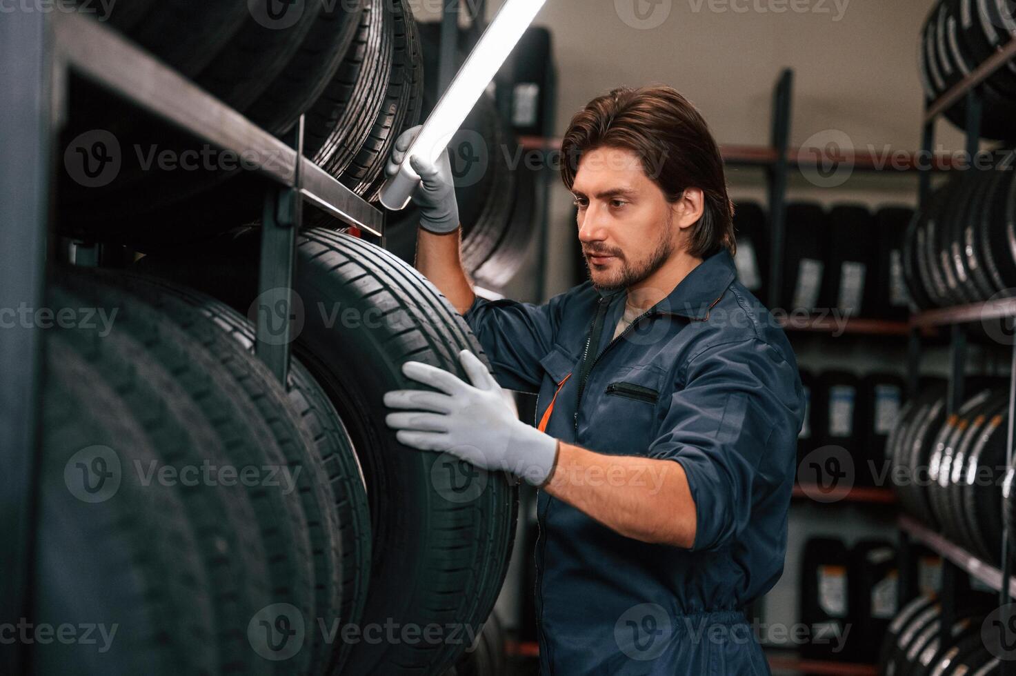 Work ,in,, progress,, manager is in warehouse. Man is in the tire fitting car service photo