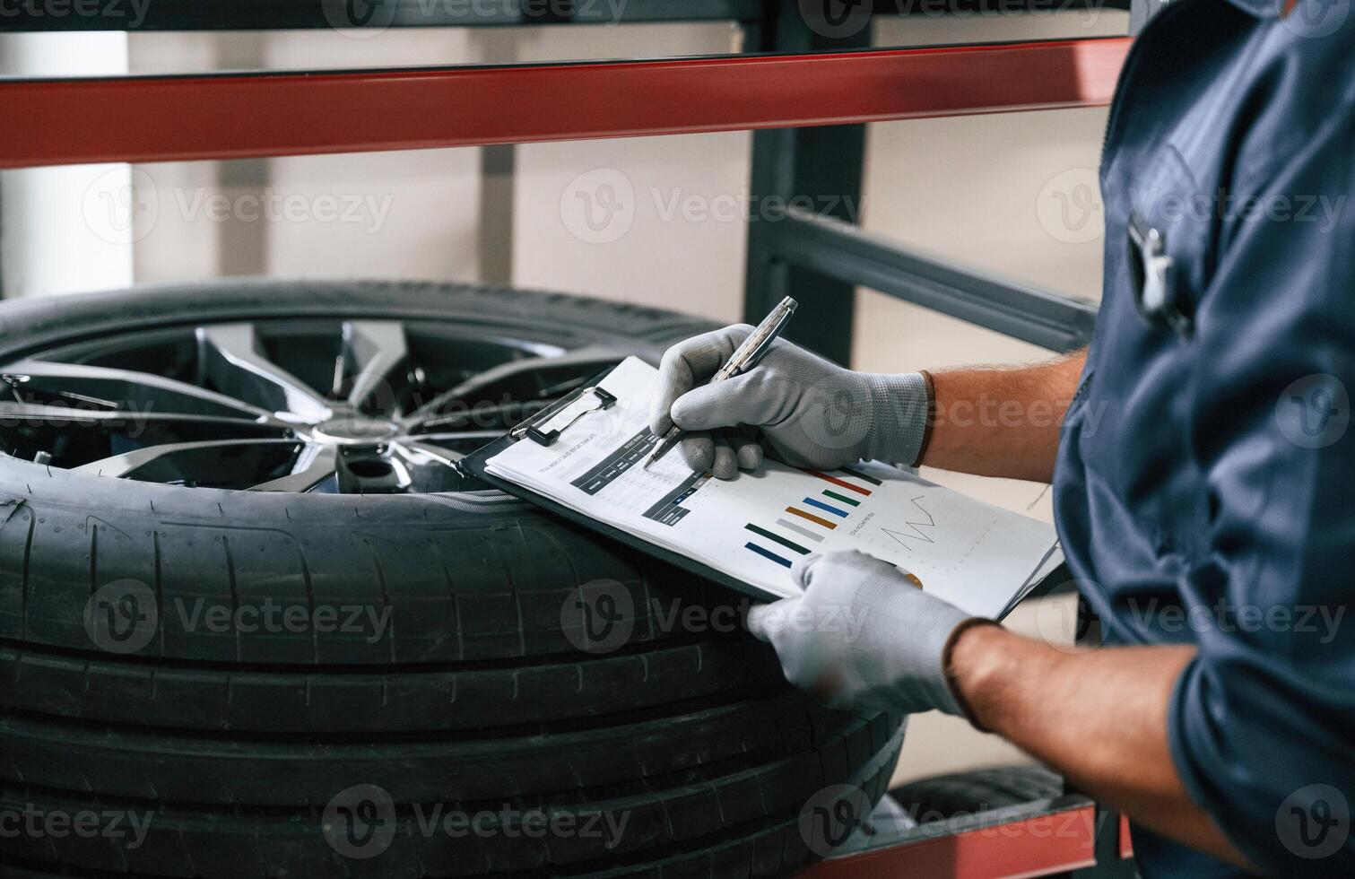 Work, in, progress, manager is in warehouse. Man is in the tire fitting car service photo
