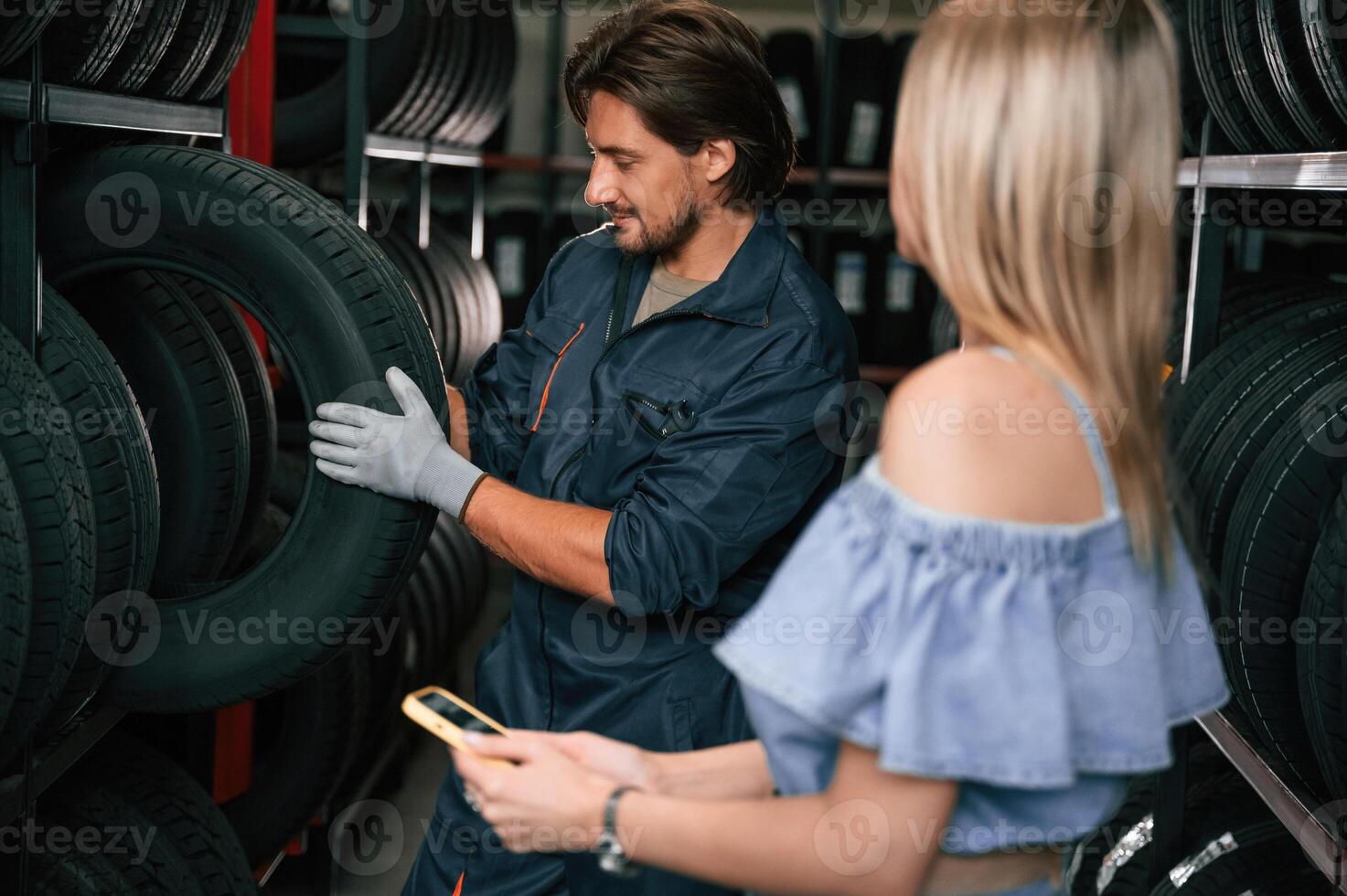 Woman, is in the tire fitting auto shop with worker photo