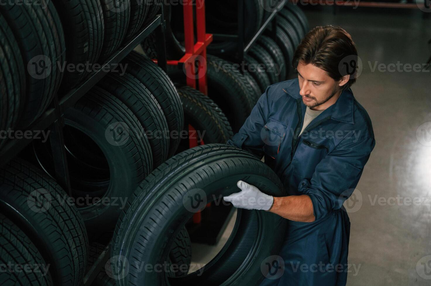 Taking ,one, tire to for changing. Man is in the tire fitting car service photo