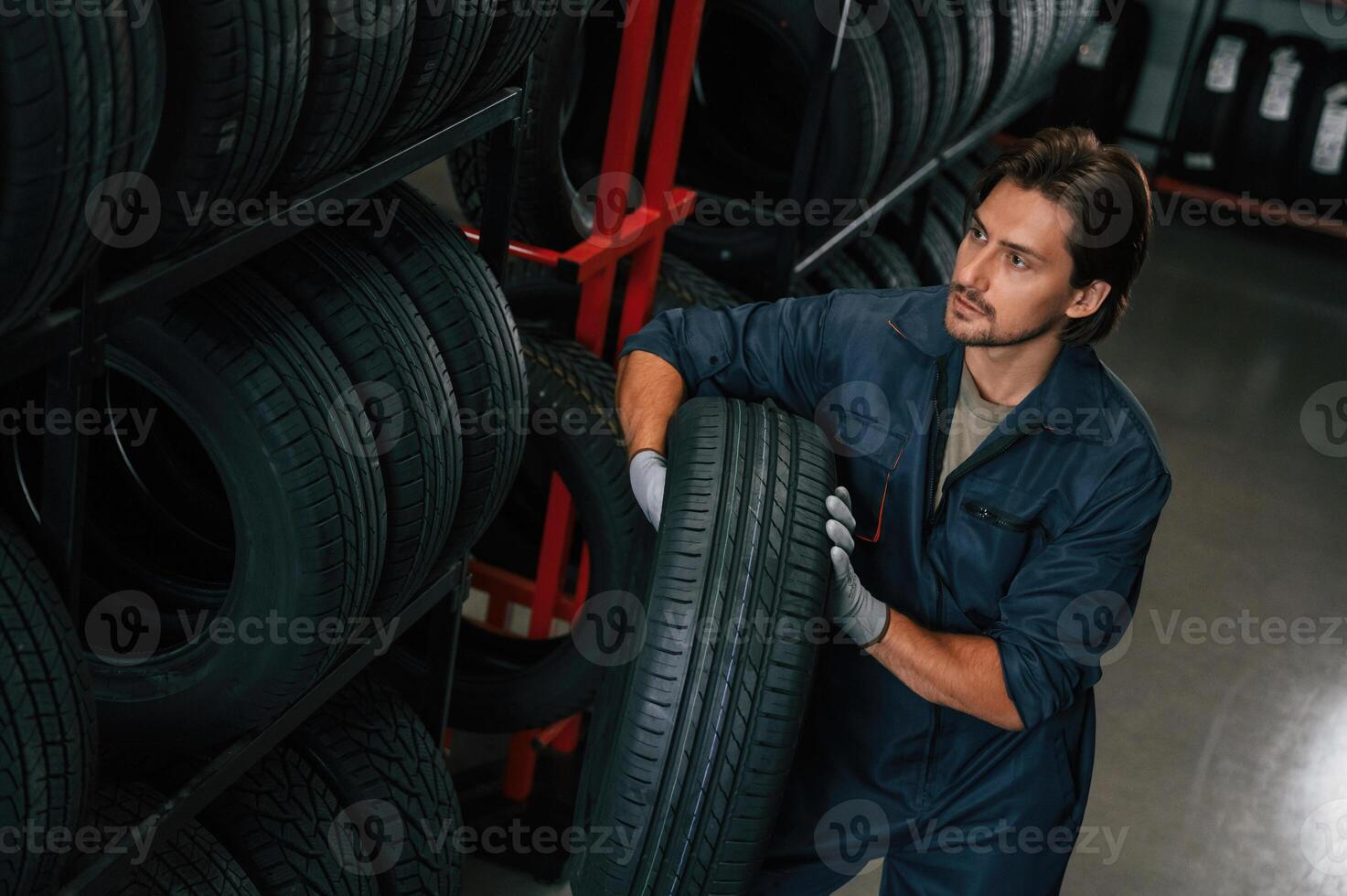 Taking ,,one tire to for changing. Man is in the tire fitting car service photo
