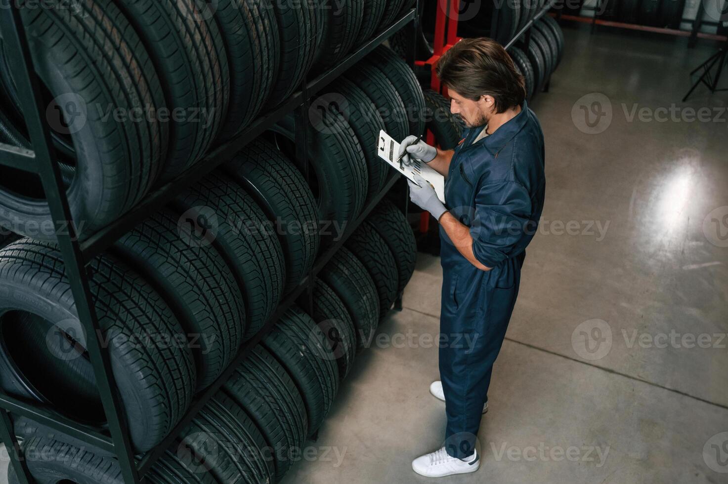 Collecting, information, counting, notepad. Man is in the tire fitting car service photo
