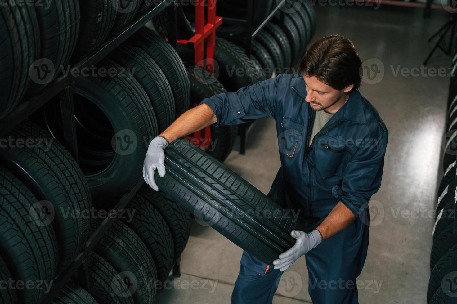 Taking, one tire to for changing. Man is in the tire fitting car service photo