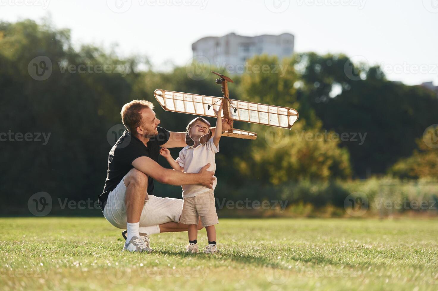 Weekend activities. Father and,, son are on the field together with toy plane photo