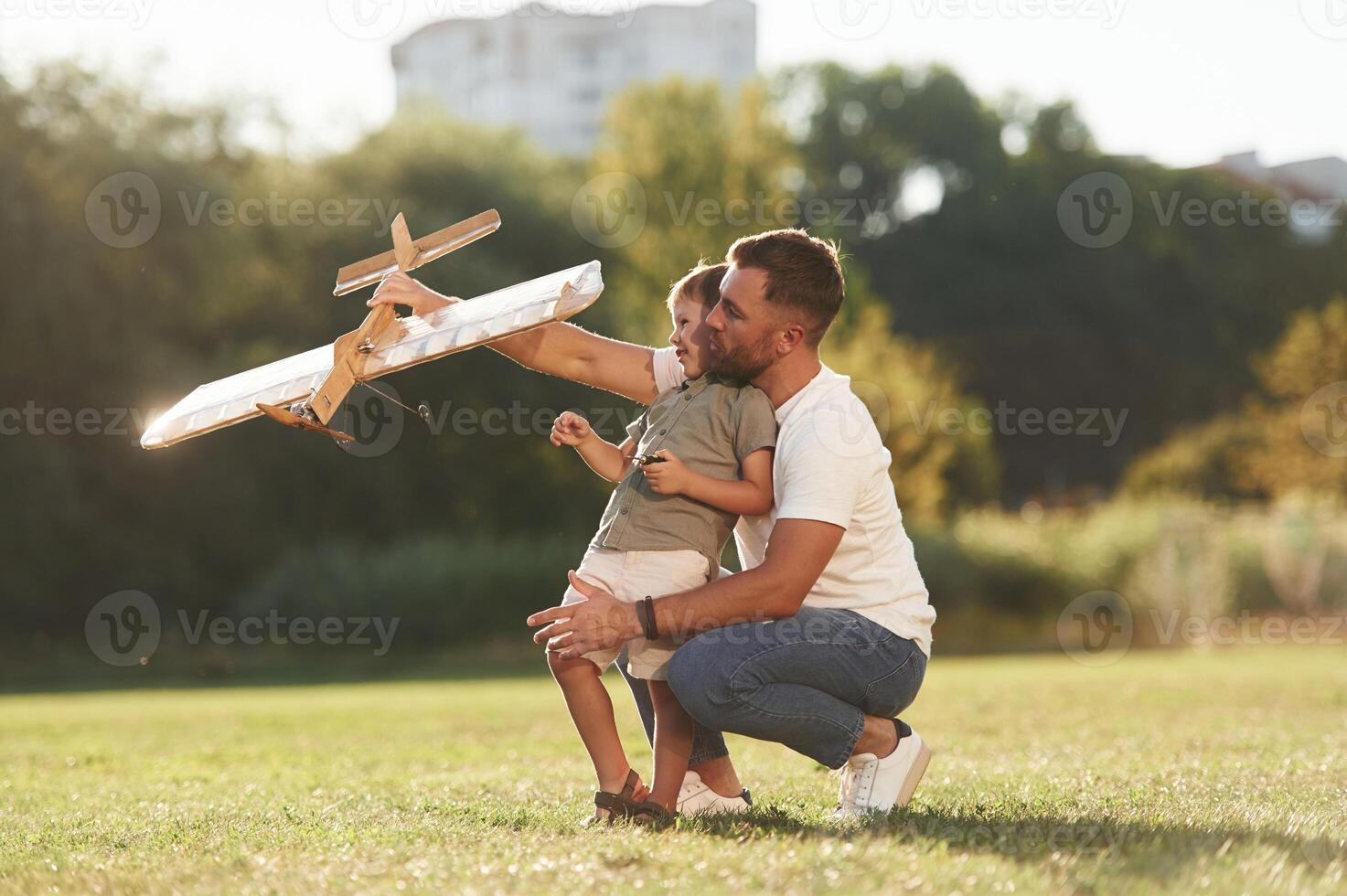 Joy, fun,,,, weekend activities. Father and son are on the field together with toy plane photo