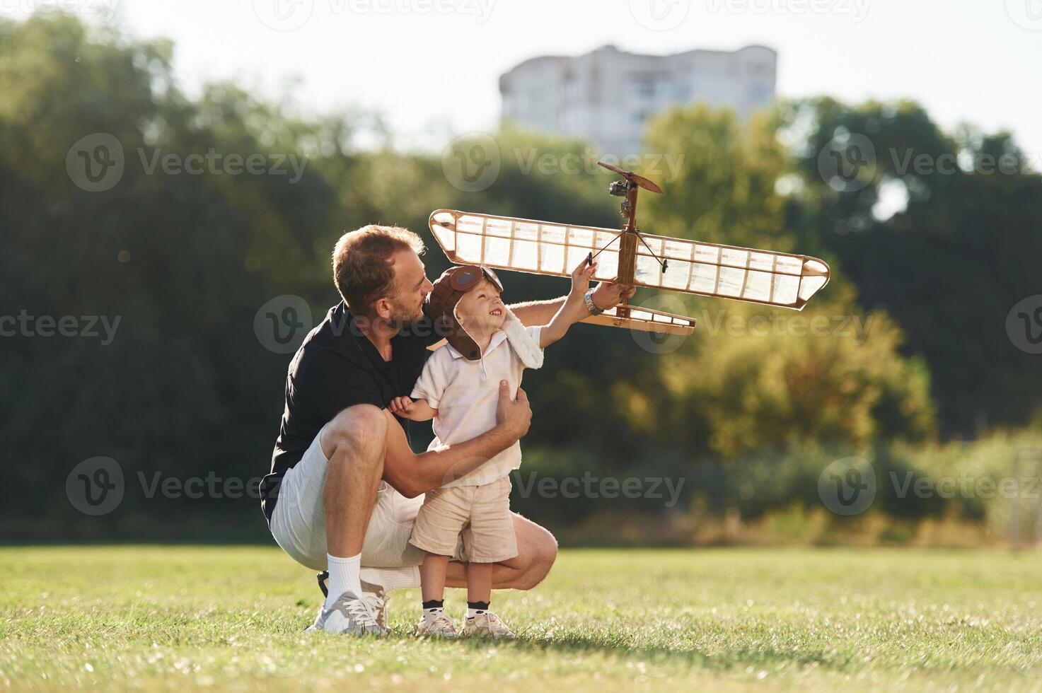 Playful mood. Father ,and, son ,are on the field together with toy plane photo