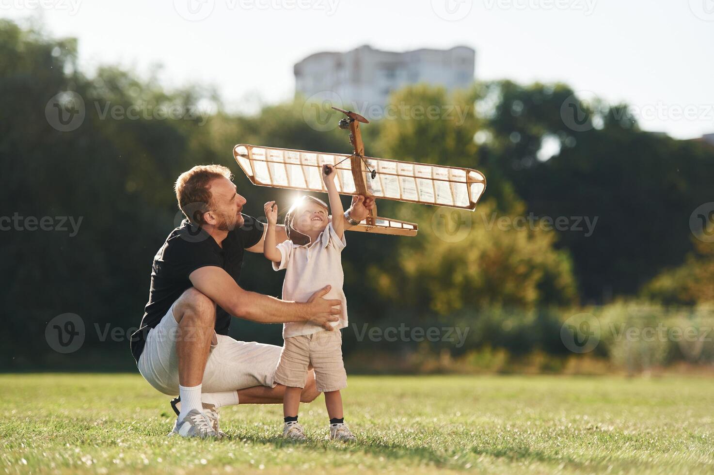 Playful, mood. Father and son are on the field together with toy plane photo