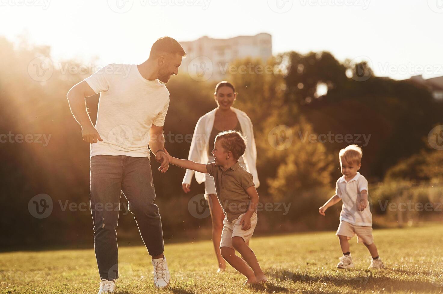 Parents with, two little sons are on the field together photo