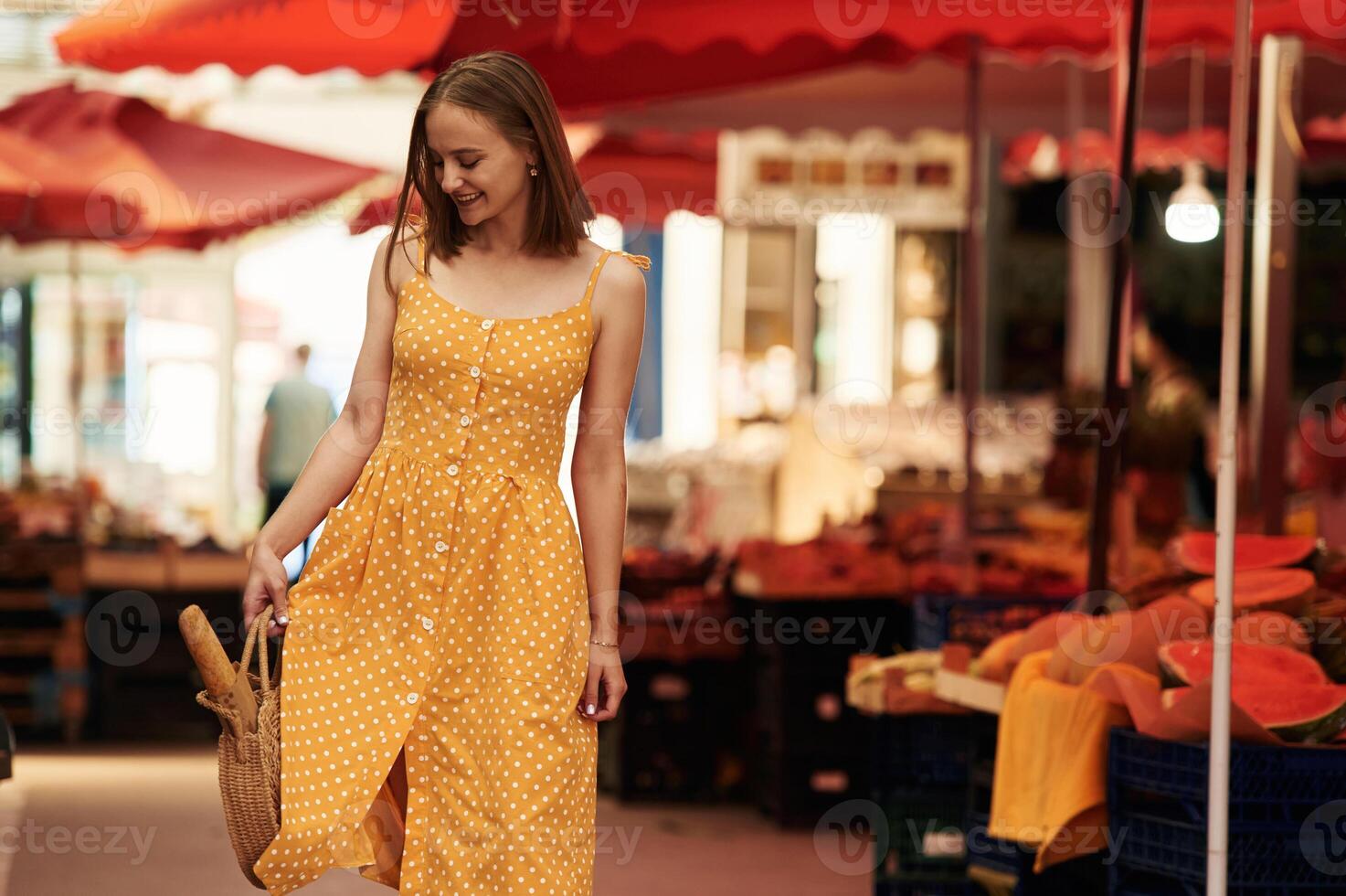 With baguette. Young woman ,is ,on, the vegetable market or bazaar photo