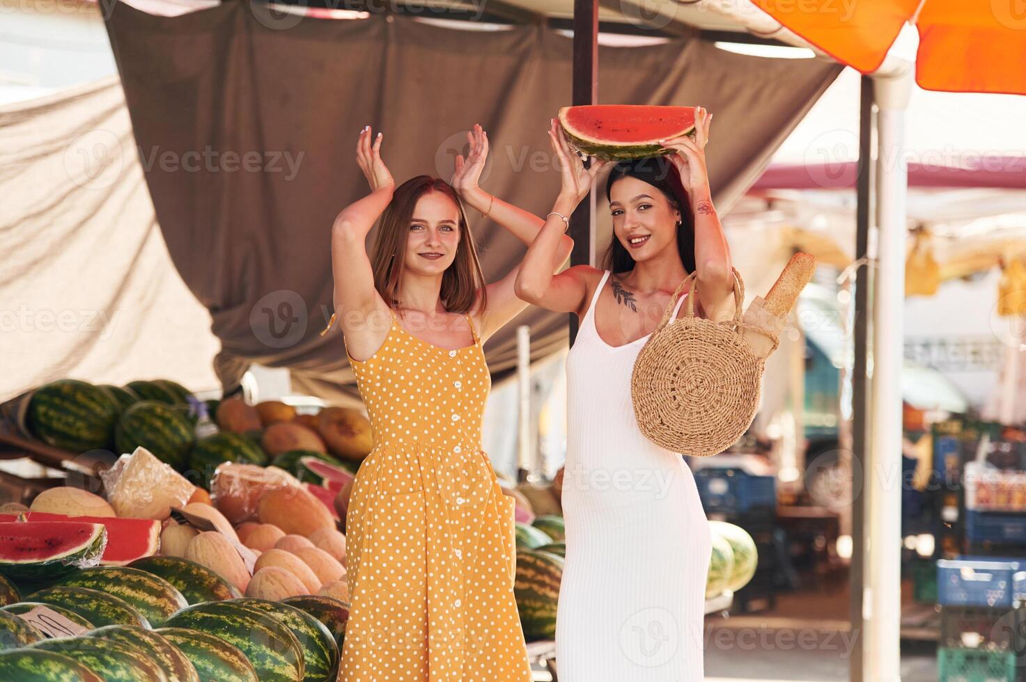 Having fun, with watermelon. Two women are together on the marker or bazaar photo