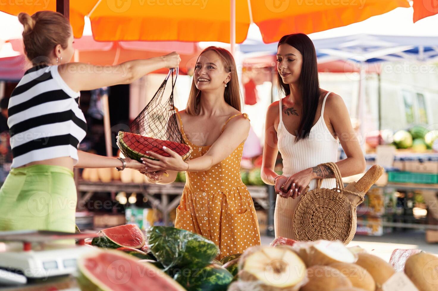 Red fresh ,watermelon. Two,, women are together on the marker or bazaar photo
