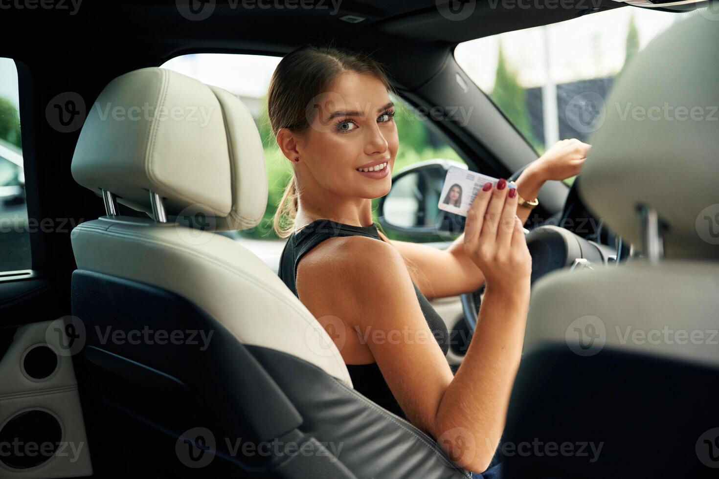 Got, driver's, license. Woman is sitting in the car photo