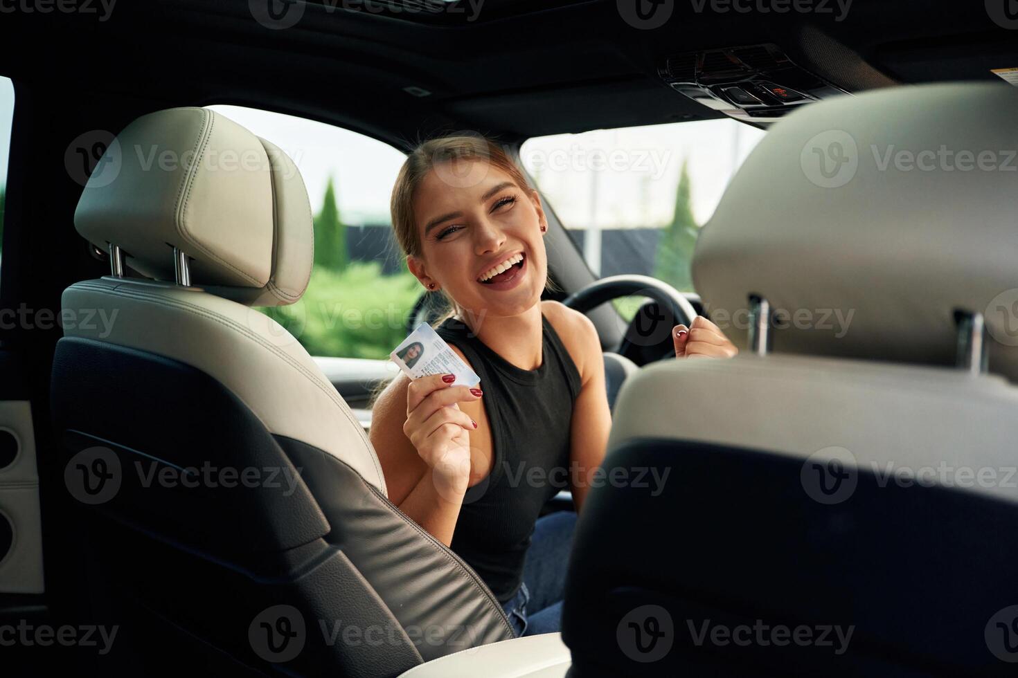 Got ,driver's license. Woman is sitting in the car photo