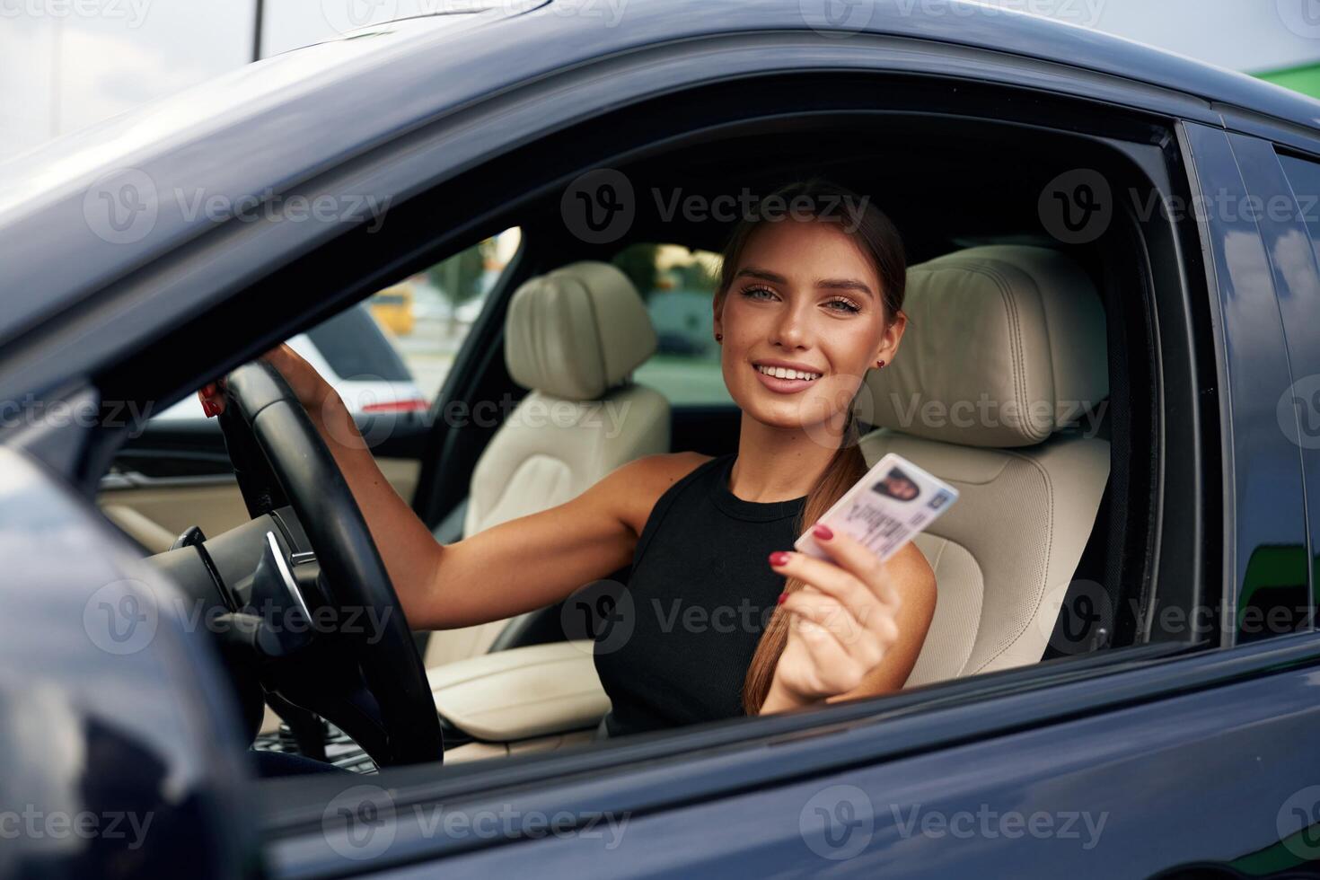 Showing ,,off with the driver's license. Woman is sitting in the car photo