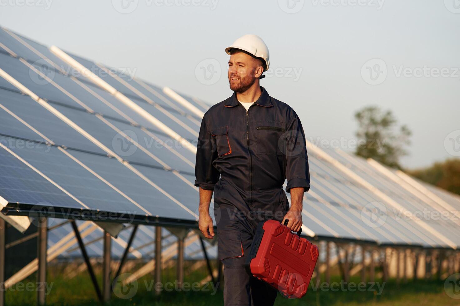 Case in the hand. Man is working with solar panels outdoors at daytime... photo