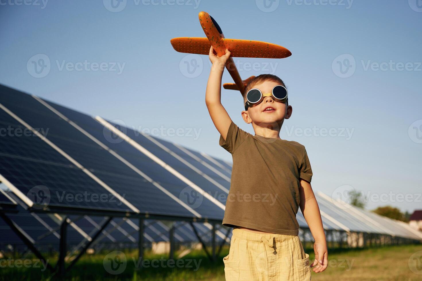 Time, to, fly., Aviator glasses and toy plane. Little boy is with solar panels outdoors photo