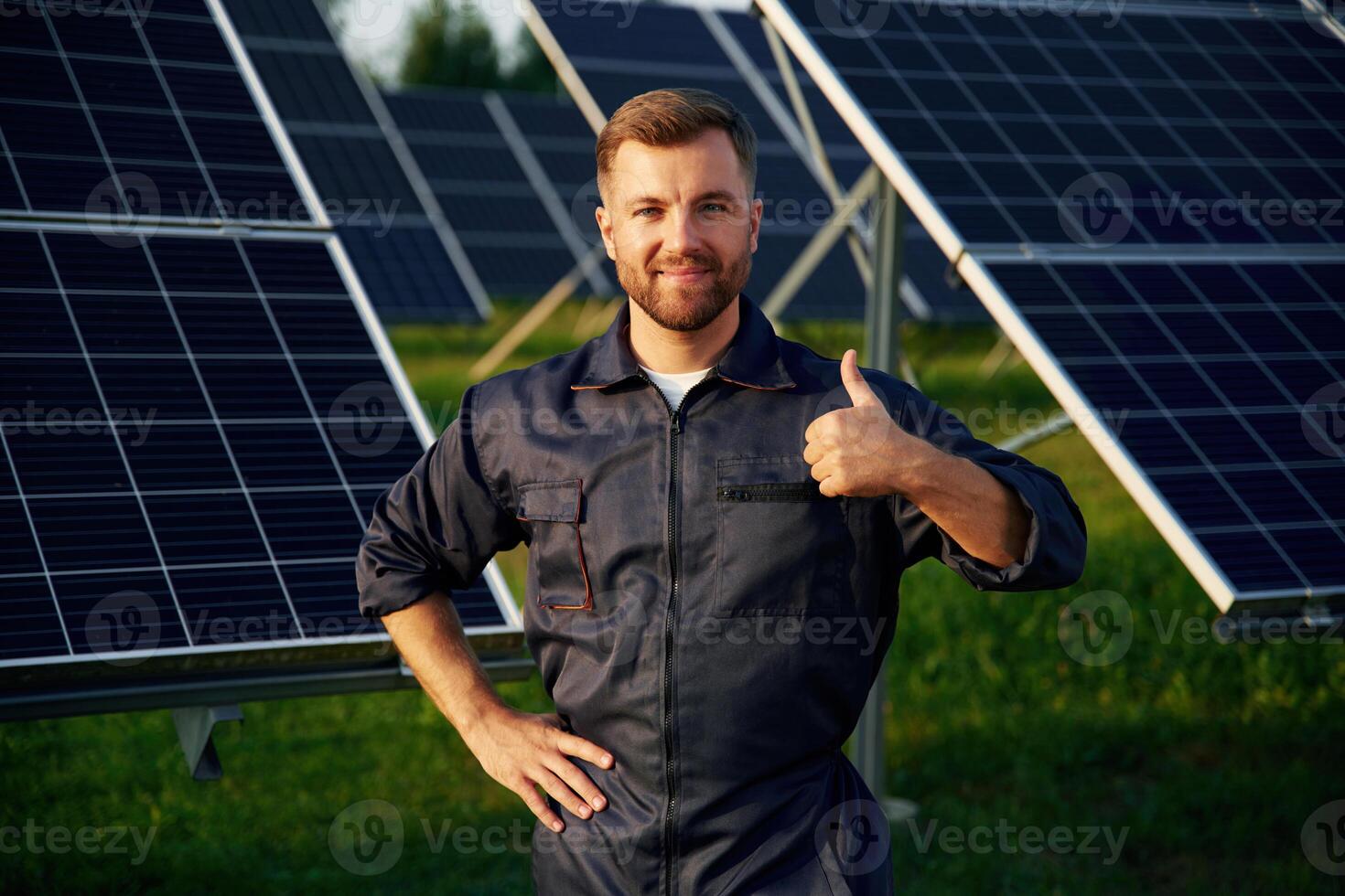 Portrait, standing with arms crossed., Man ,is working with solar panels outdoors at daytime photo