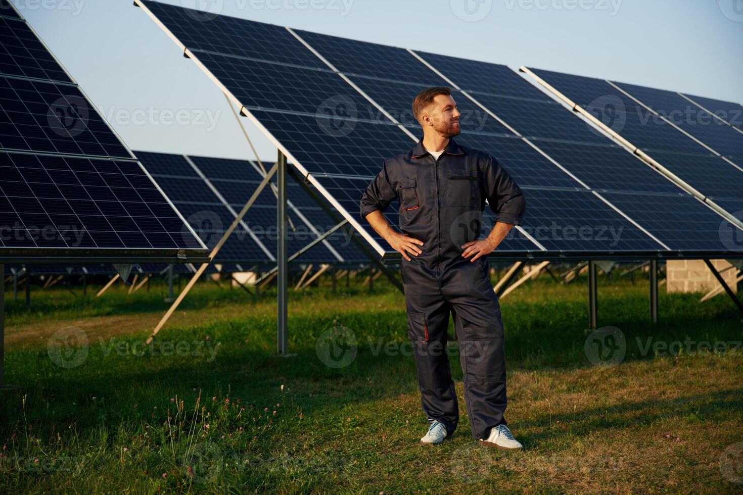 Taking ,a,,, break, standing. Man is working with solar panels outdoors at daytime photo