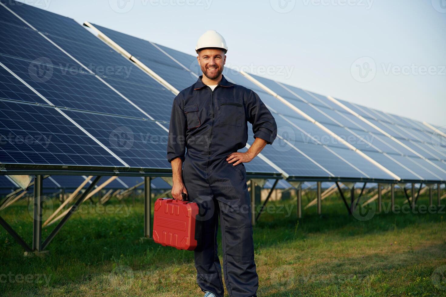 Case in the hand. Man is working ,,with solar panels outdoors at daytime photo
