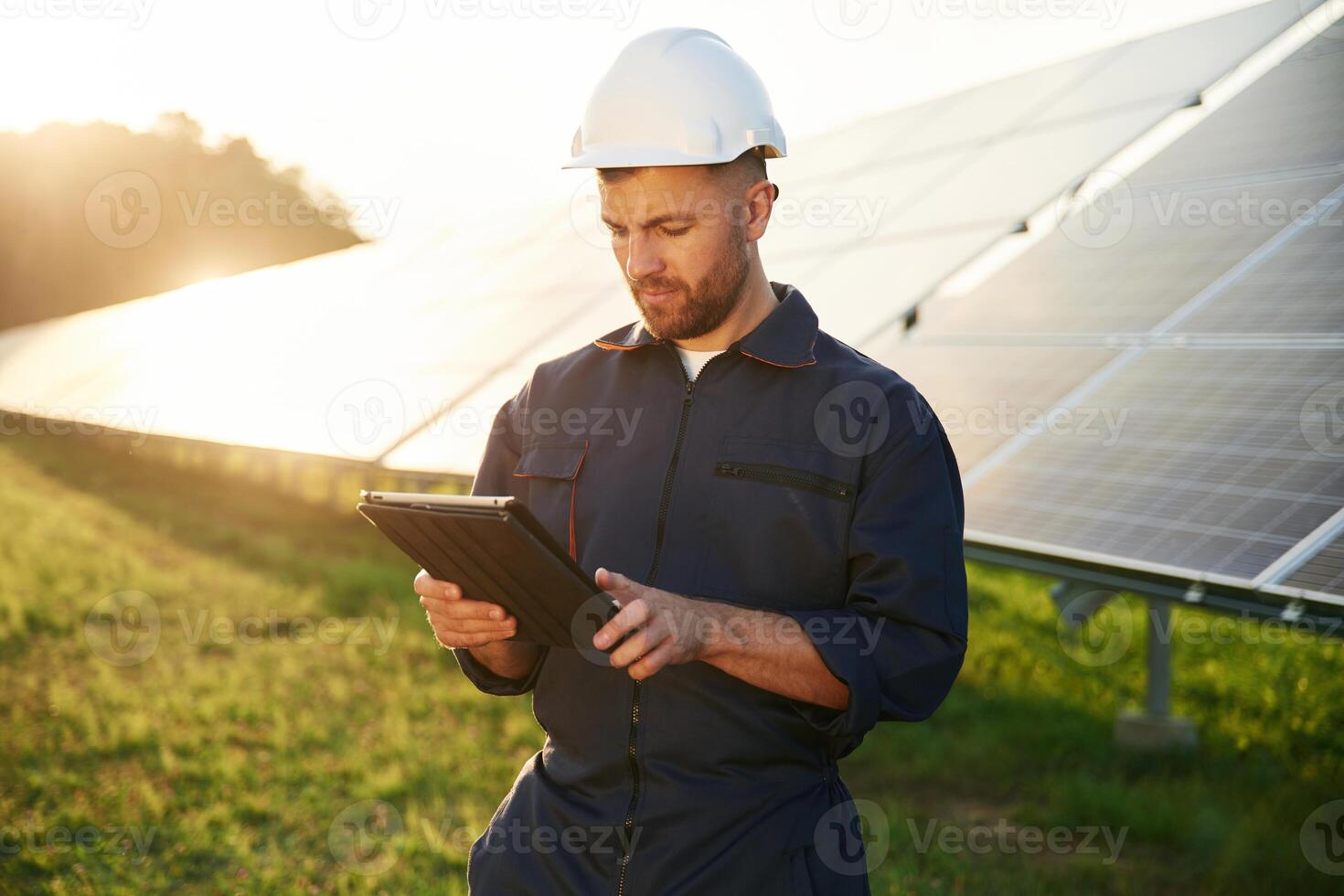 Reflection, of ,the, sunlight behind. Man is working with solar panels outdoors at daytime photo