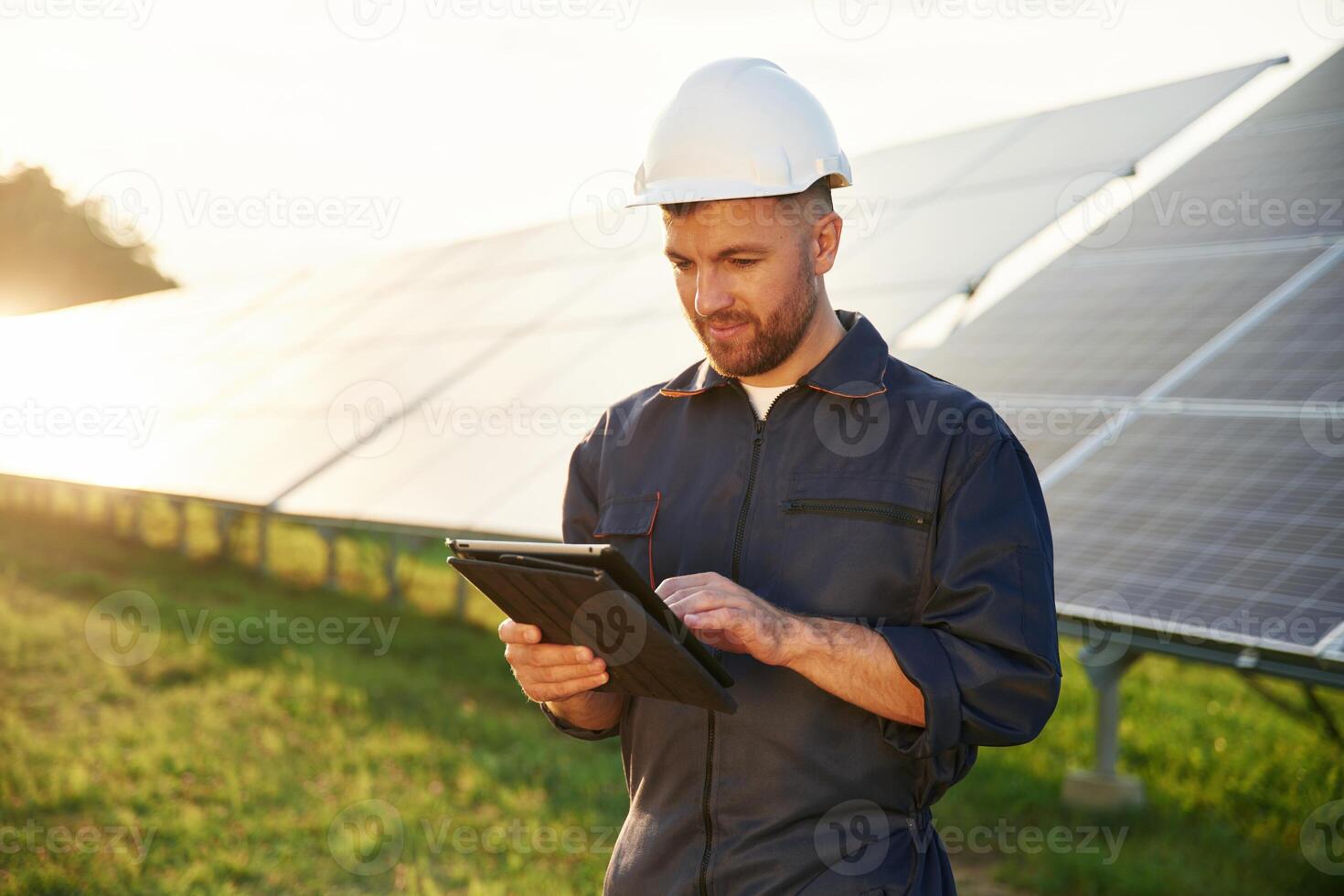 Reflection, of, the sunlight behind. Man is working with solar panels outdoors at daytime photo
