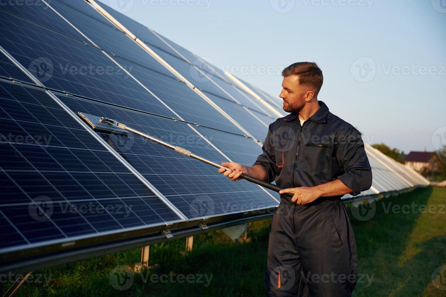 Keep it ,clean. Man is working with solar panels outdoors at daytime photo