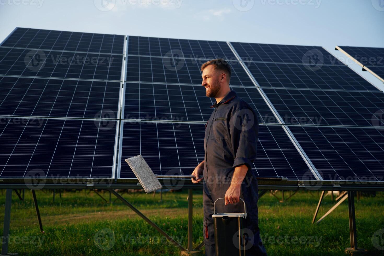 Keep,, it clean. Man is working with solar panels outdoors at daytime photo