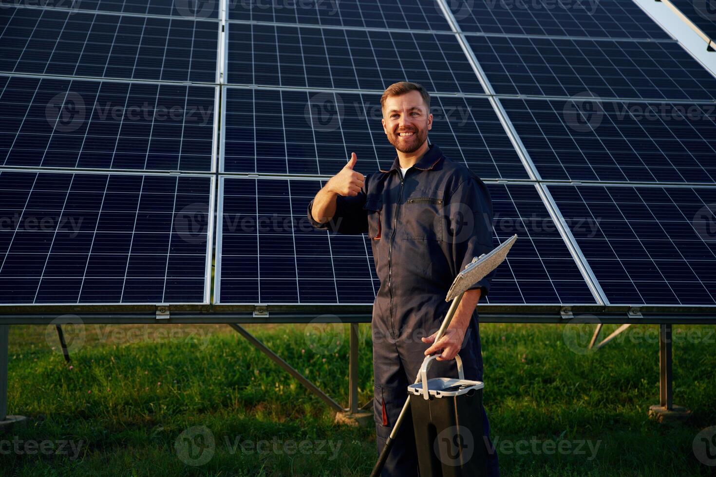 Keep,,, it clean. Man is working with solar panels outdoors at daytime photo