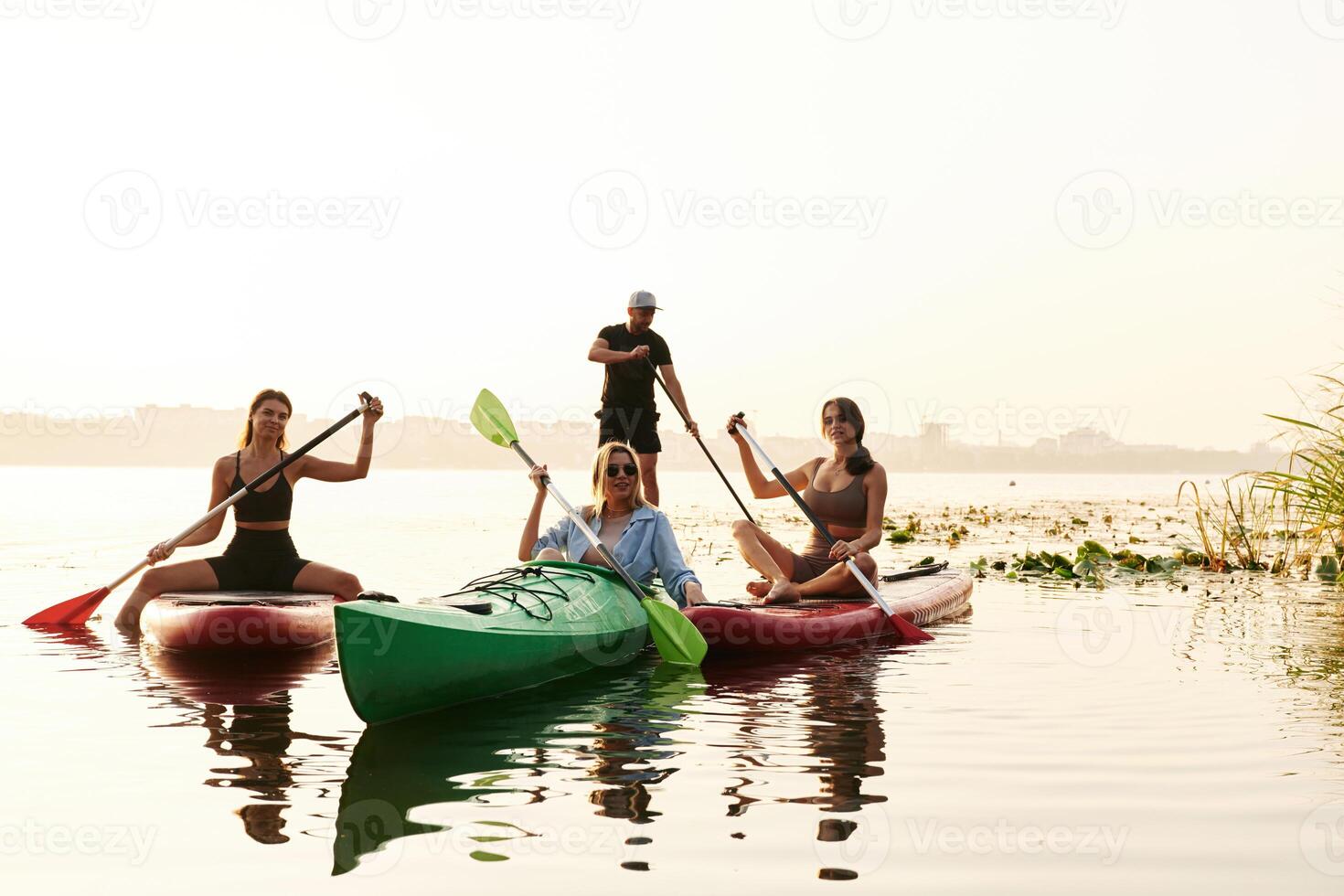 Women and man. Friends, are together on sup boards on the lake photo