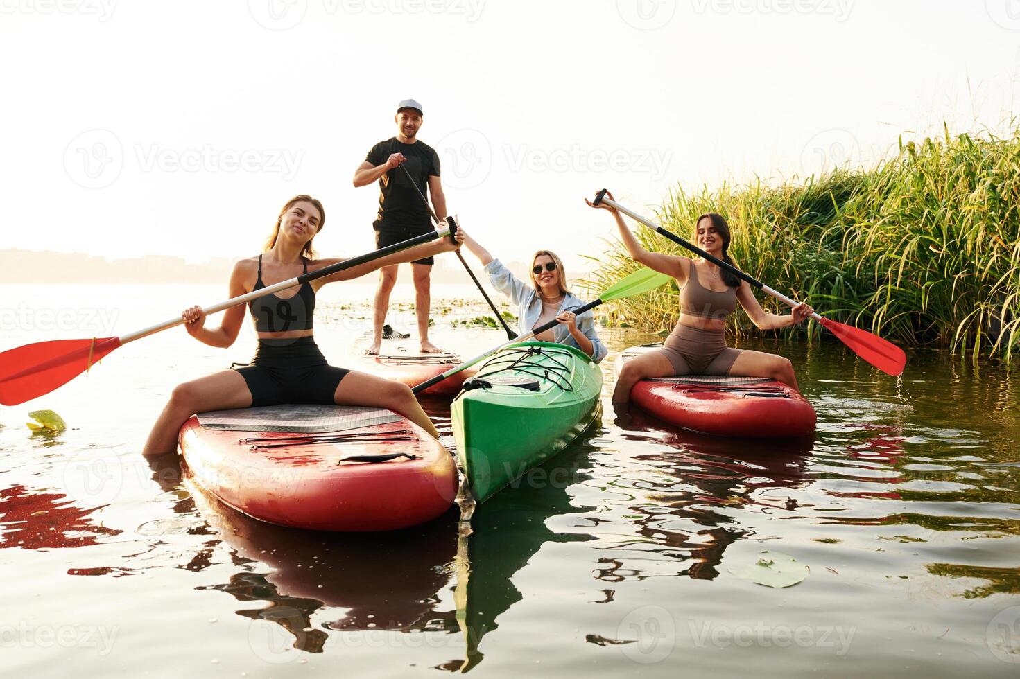 Women ,and man. Friends are together on sup boards on the lake photo